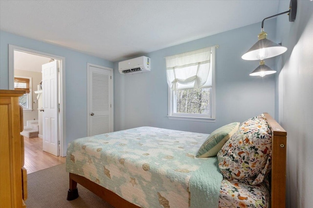 25 Sawmill Ln, Ogunquit, ME 03907 - bedroom featuring an AC wall unit, wood finished floors, ensuite bath, and a closet
