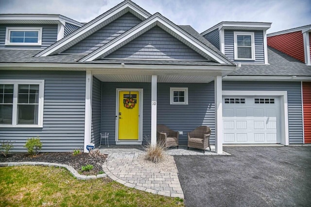 10 Haleys Ct Unit 22, Wells, ME 04090 - view of front of house with a garage, a porch, roof with shingles, and driveway