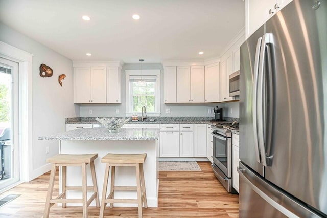 10 Haleys Ct Unit 22, Wells, ME 04090 - kitchen with stainless steel appliances, a sink, light wood-style floors, white cabinets, and recessed lighting