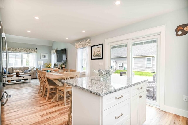 10 Haleys Ct Unit 22, Wells, ME 04090 - kitchen with open floor plan, white cabinetry, light stone counters, a center island, and light wood-style floors