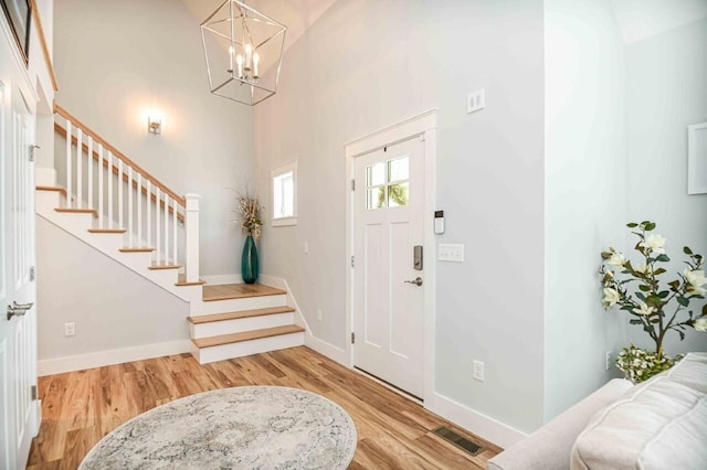 10 Haleys Ct Unit 22, Wells, ME 04090 - foyer featuring stairs, wood finished floors, a chandelier, a high ceiling, and baseboards