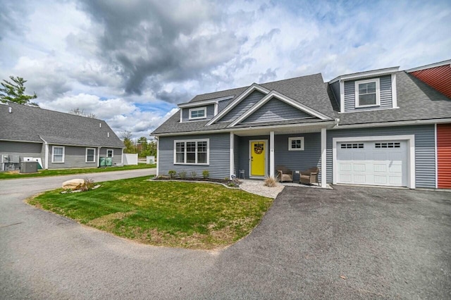 10 Haleys Ct Unit 22, Wells, ME 04090 - view of front of house with roof with shingles, asphalt driveway, a front lawn, and an attached garage