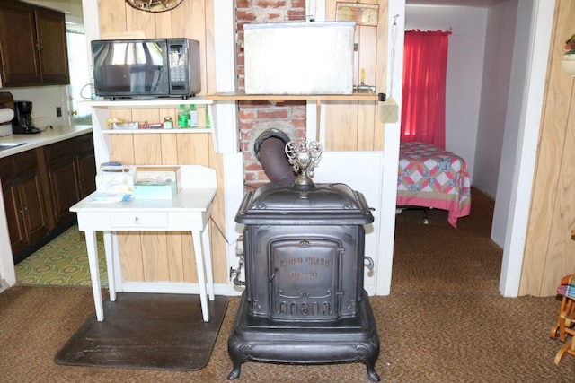 68 Salmon Rd, Madison, ME 04950 - details featuring a wood stove, carpet flooring, and black microwave