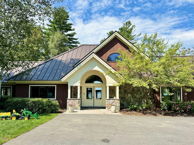 129 Loon Call Dr, Belgrade, ME 04917 - view of front facade with a standing seam roof, stone siding, and metal roof