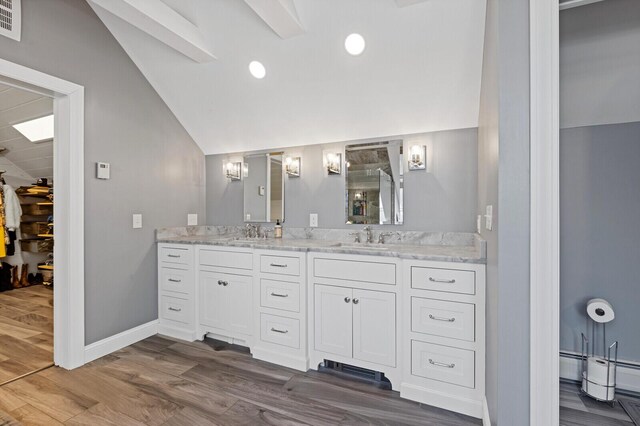129 Loon Call Dr, Belgrade, ME 04917 - bathroom with lofted ceiling, a tile shower, double vanity, wood finished floors, and baseboards