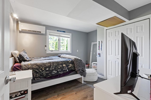 129 Loon Call Dr, Belgrade, ME 04917 - bedroom featuring an AC wall unit, wood finished floors, and a closet