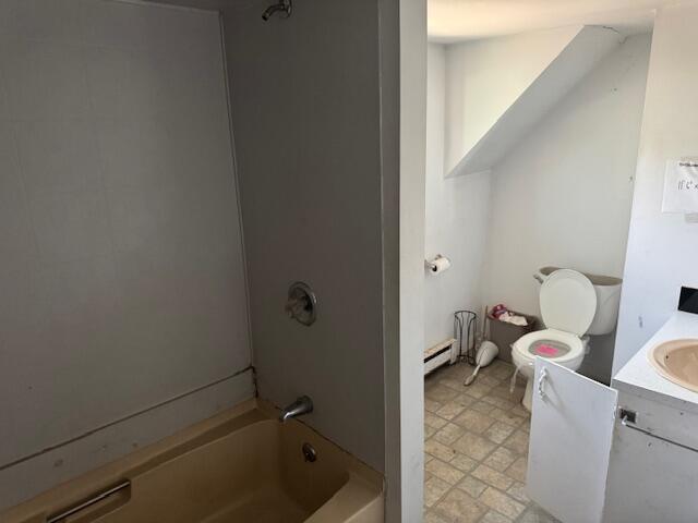 bathroom featuring  shower combination, vanity, toilet, and a baseboard radiator