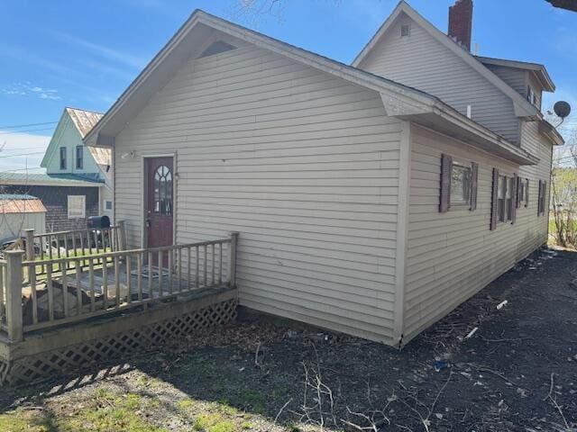 view of property exterior featuring a chimney and a wooden deck