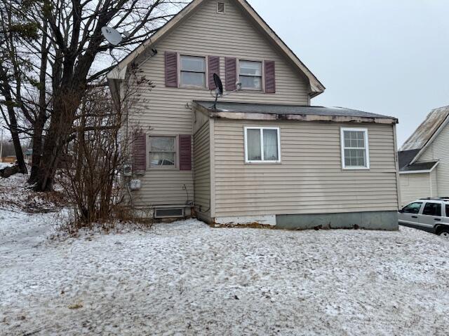 view of snow covered back of property