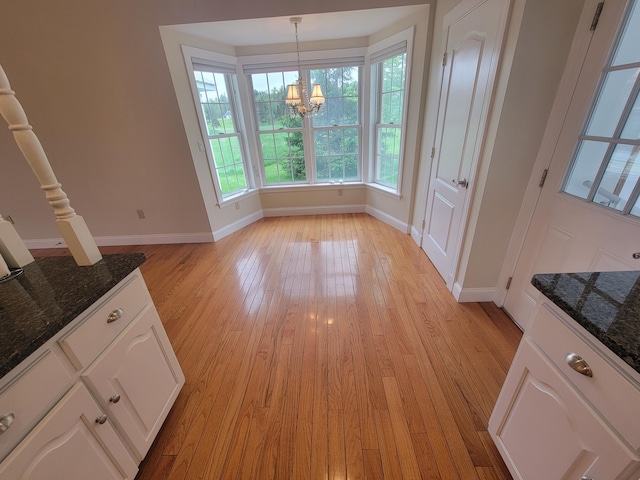 239 Pierce Rd Unit 2B, Brewer, ME 04412 - unfurnished dining area with baseboards, a chandelier, and light wood-style floors