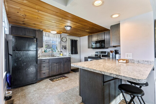 2 Airport Rd, Turner, ME 04282 - kitchen with black appliances, a peninsula, a sink, a kitchen bar, and wood ceiling
