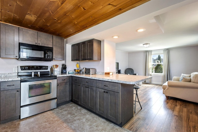 2 Airport Rd, Turner, ME 04282 - kitchen featuring black microwave, stainless steel range with electric cooktop, a breakfast bar, a peninsula, and open floor plan