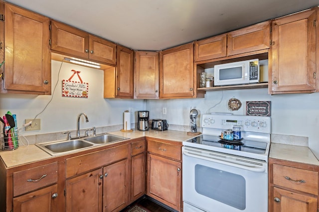 2 Airport Rd, Turner, ME 04282 - kitchen with white appliances, a sink, light countertops, and brown cabinetry