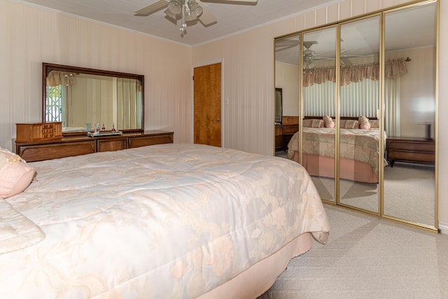 bedroom with ornamental molding, carpet flooring, a closet, and ceiling fan
