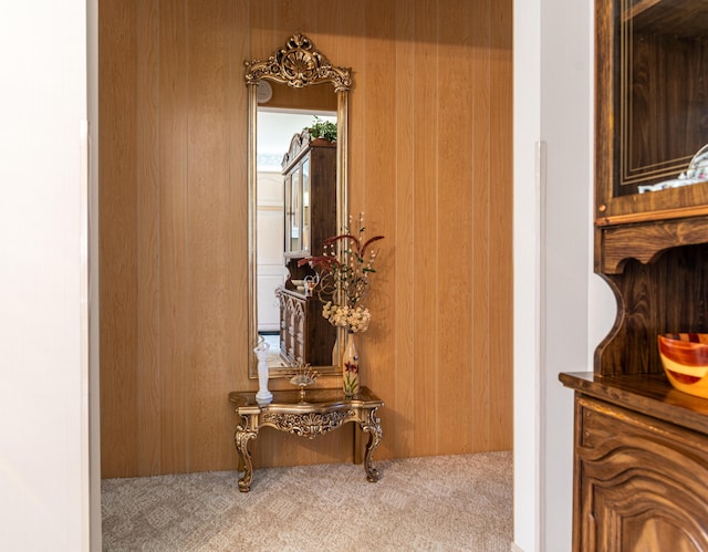 hall featuring carpet floors and wood walls