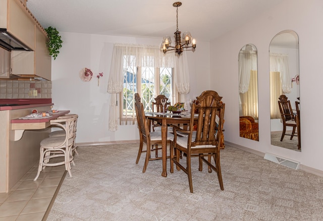 dining space with a chandelier, light carpet, and baseboards