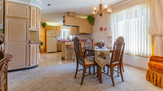 dining area featuring a chandelier and light colored carpet