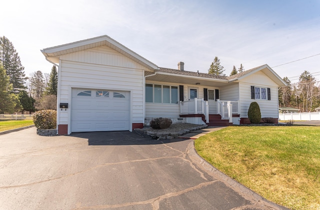 ranch-style home with driveway, an attached garage, and a front lawn