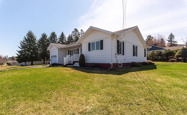 ranch-style house featuring an attached garage, a front lawn, and driveway