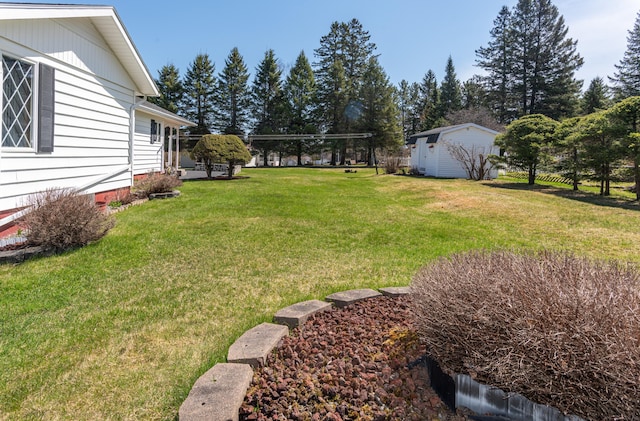 view of green lawn with an outbuilding