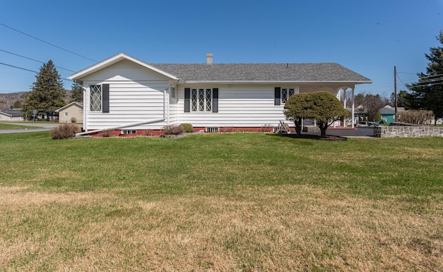 rear view of property with a lawn and a shingled roof