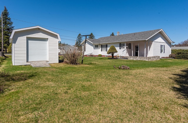 back of property featuring a lawn, an outdoor structure, a storage unit, and roof with shingles