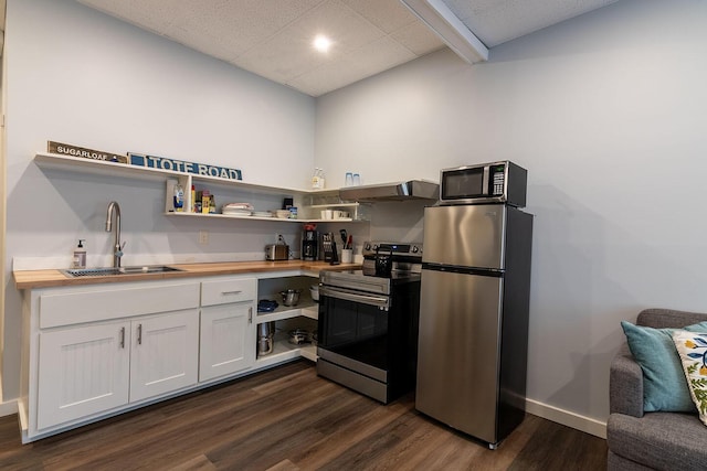 kitchen with dark wood-style flooring, a sink, wood counters, open shelves, and appliances with stainless steel finishes