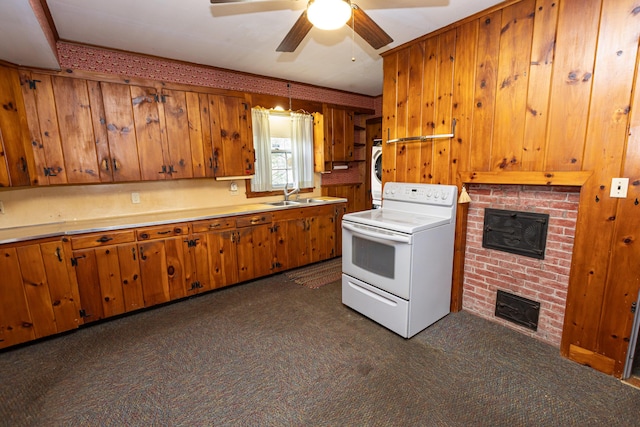 151 Summer St, Kennebunk, ME 04043 - kitchen with white electric range, a sink, a brick fireplace, brown cabinetry, and dark colored carpet