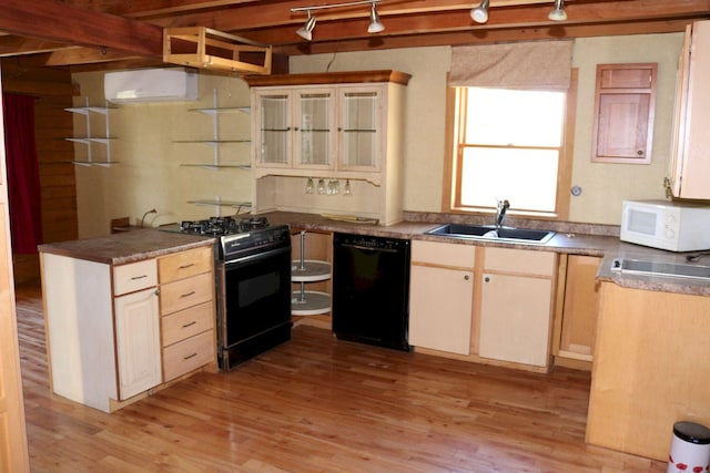 50 Widgeon Rd, Madison, ME 04950 - kitchen with an AC wall unit, light wood finished floors, a sink, rail lighting, and black appliances