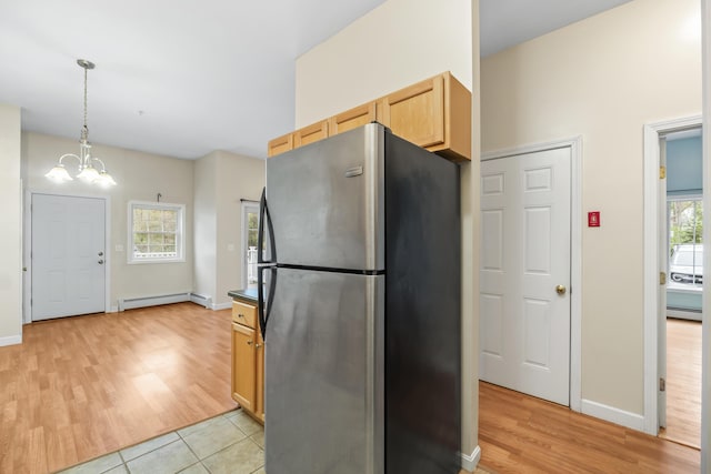 kitchen featuring freestanding refrigerator, baseboard heating, a chandelier, and light wood-type flooring