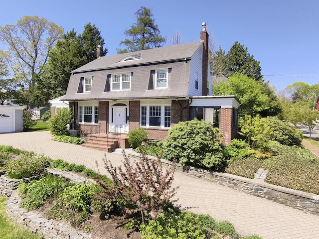 14 Highland St, Portland, ME 04103 - view of front of house featuring a gambrel roof, brick siding, and a chimney
