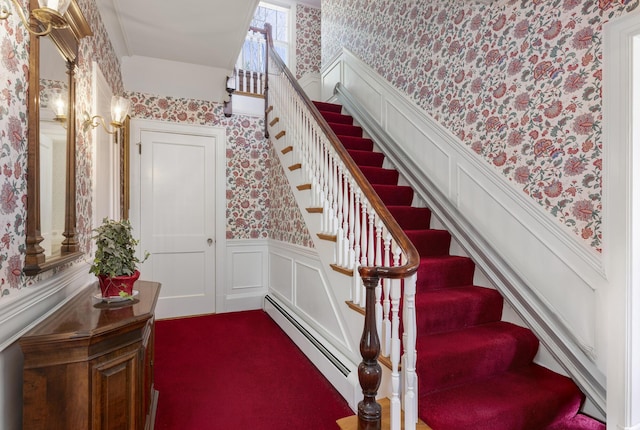 14 Highland St, Portland, ME 04103 - stairway featuring wallpapered walls, a baseboard radiator, a wainscoted wall, and a decorative wall