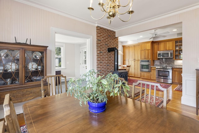 14 Highland St, Portland, ME 04103 - dining area featuring a wood stove, a chandelier, ornamental molding, light wood finished floors, and a ceiling fan