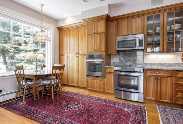 14 Highland St, Portland, ME 04103 - kitchen with appliances with stainless steel finishes, brown cabinetry, light wood-style floors, and light stone counters