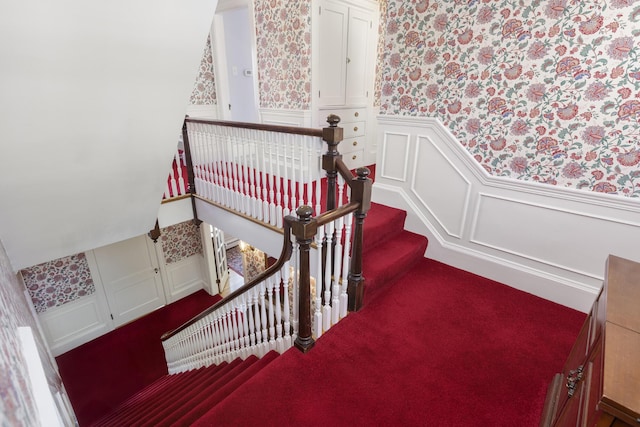 14 Highland St, Portland, ME 04103 - stairway featuring wallpapered walls, a decorative wall, wainscoting, and carpet floors