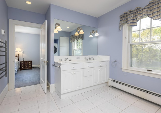 14 Highland St, Portland, ME 04103 - full bathroom with a baseboard radiator, stacked washer and clothes dryer, connected bathroom, double vanity, and baseboards