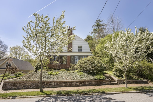 14 Highland St, Portland, ME 04103 - view of front of property featuring a chimney, brick siding, and a gambrel roof