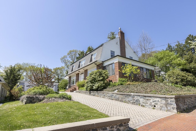 14 Highland St, Portland, ME 04103 - view of side of home with brick siding, a chimney, and a yard