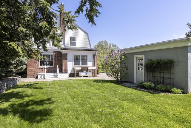 14 Highland St, Portland, ME 04103 - back of house featuring a patio, a yard, and brick siding