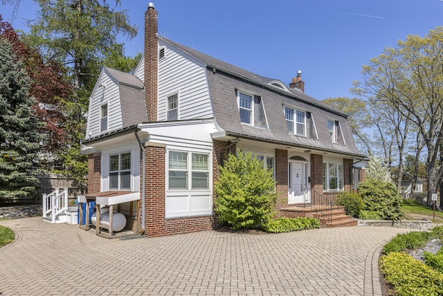 14 Highland St, Portland, ME 04103 - view of front of house with a chimney, a gambrel roof, and brick siding