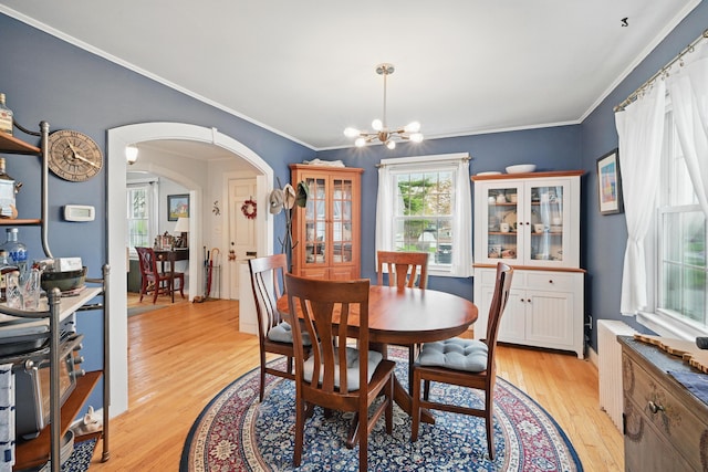 51 Googin St, Lewiston, ME 04240 - dining room featuring a chandelier, arched walkways, light wood-style flooring, and ornamental molding