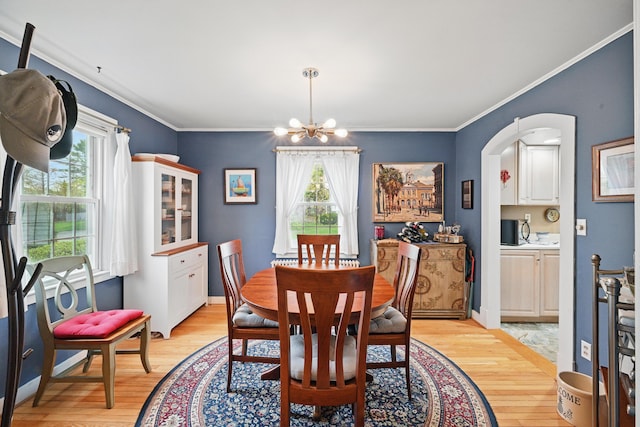 51 Googin St, Lewiston, ME 04240 - dining space featuring healthy amount of natural light, a chandelier, light wood-style floors, crown molding, and arched walkways