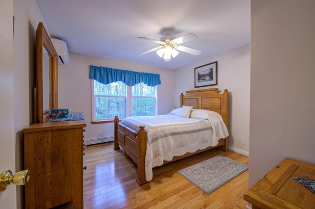 229 Stone Rd, Newfield, ME 04095 - bedroom featuring a baseboard radiator, light wood-style floors, a wall unit AC, and a ceiling fan