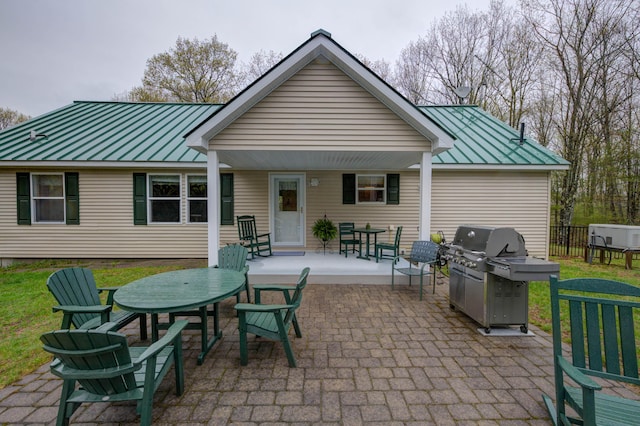 229 Stone Rd, Newfield, ME 04095 - rear view of house featuring a standing seam roof, metal roof, outdoor dining space, and a patio area