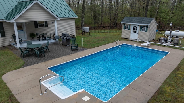 229 Stone Rd, Newfield, ME 04095 - view of swimming pool with an outdoor structure, a patio area, a grill, a diving board, and a shed