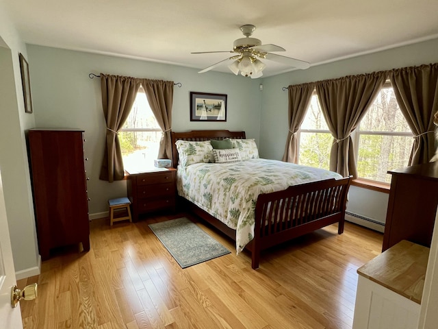 229 Stone Rd, Newfield, ME 04095 - bedroom with baseboard heating, light wood-style flooring, a ceiling fan, and baseboards
