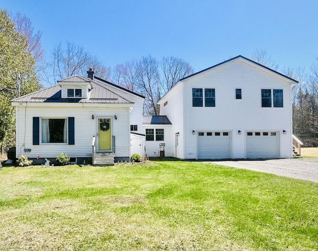 14 Fields Pond Rd, Holden, ME 04429 - view of front facade with driveway, a front yard, metal roof, an attached garage, and entry steps