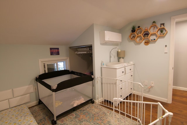 14 Fields Pond Rd, Holden, ME 04429 - bedroom featuring baseboards, vaulted ceiling, a wall mounted AC, and wood finished floors