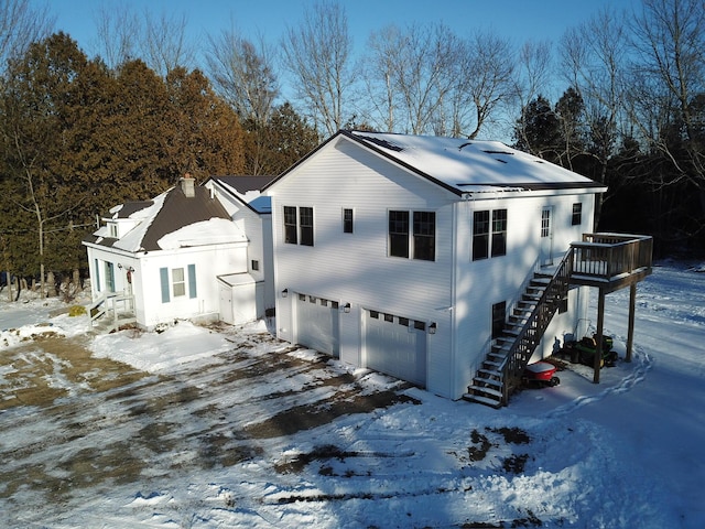 14 Fields Pond Rd, Holden, ME 04429 - snow covered property with stairway, a chimney, a garage, and aphalt driveway