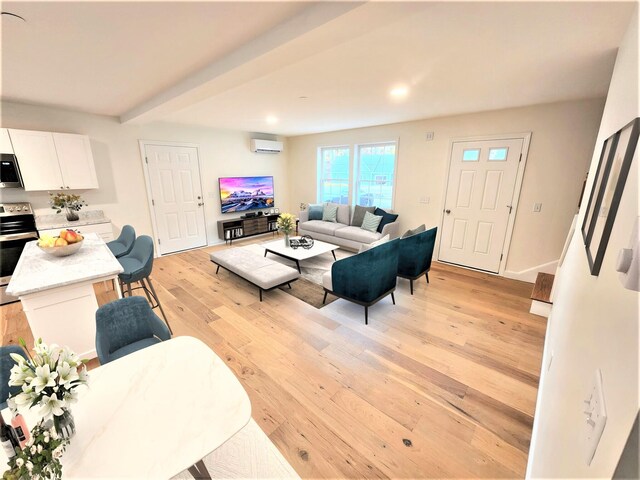 living area with light wood finished floors, recessed lighting, baseboards, and an AC wall unit